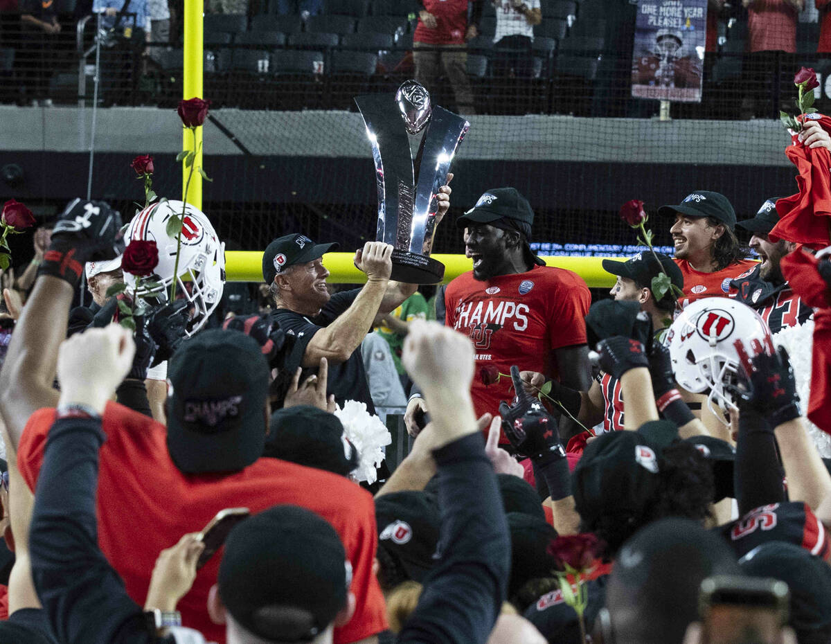 Utah Utes head coach Kyle Whittingham, left, raises the championship trophy as he celebrates wi ...