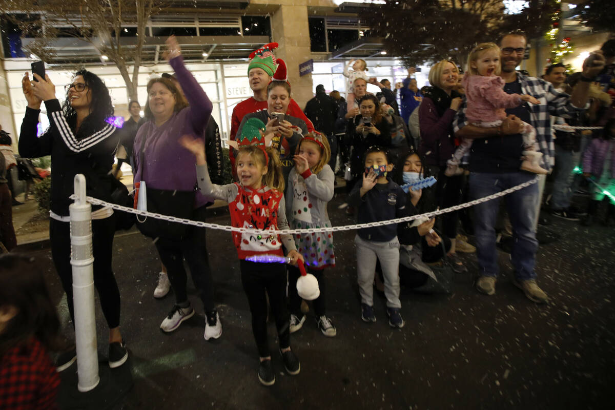 People cheer during a holiday parade at Downtown Summerlin, Friday, Dec. 3, 2021, in Las Vegas. ...