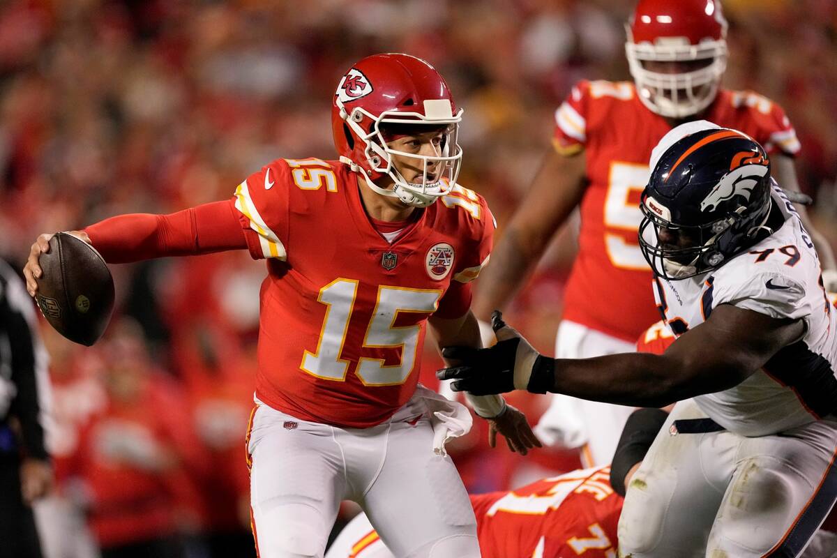 Kansas City Chiefs quarterback Patrick Mahomes (15) runs with the ball as Denver Broncos defens ...