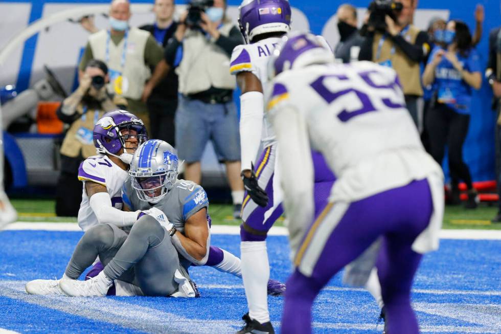 Detroit Lions wide receiver Amon-Ra St. Brown (14), defended by Minnesota Vikings cornerback Ca ...