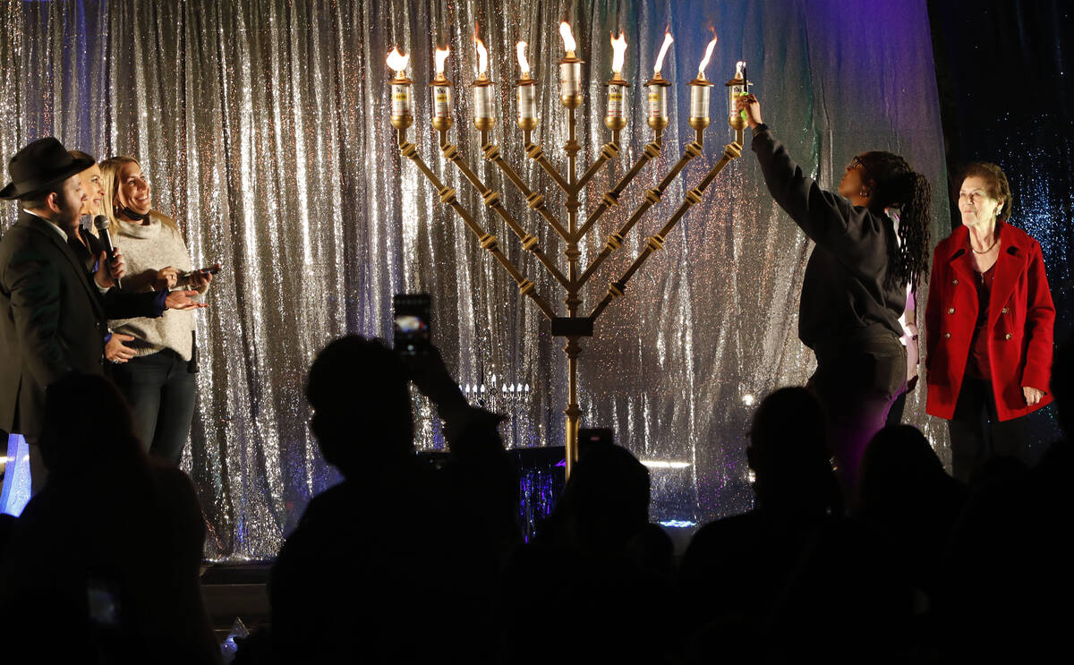 Monique Abarca with NAACP, second from right, lights a menorah on the eighth day of the Jewish ...