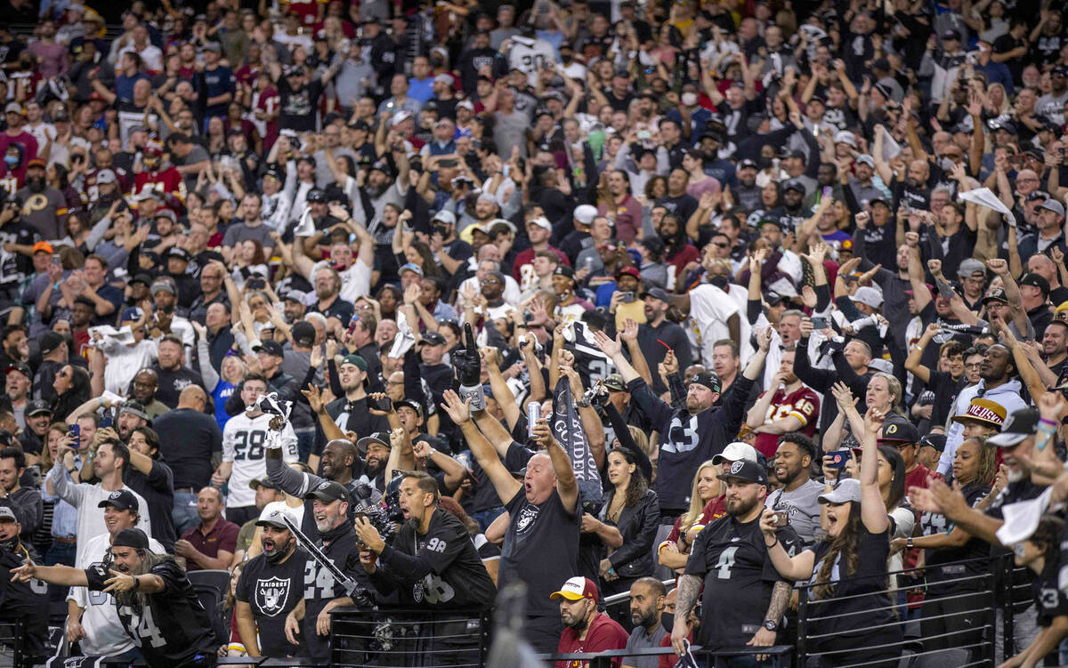 Raiders fans celebrate a running back Josh Jacobs (28) score over the Washington Football Team ...