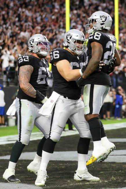 Raiders running back Josh Jacobs (28) celebrates a touchdown with center Nick Martin (66) and c ...