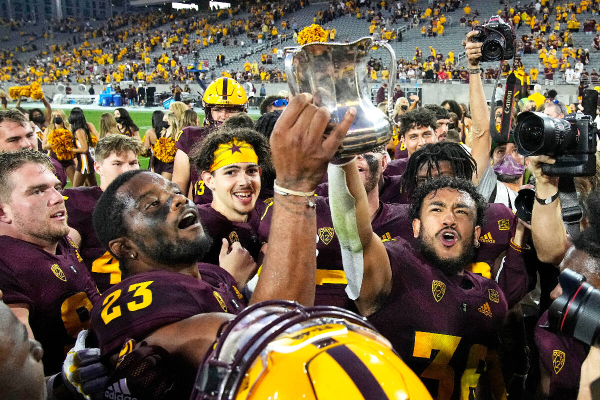 Arizona State players hold up the Territorial Cup after defeating Arizona 38-15 during an NCAA ...