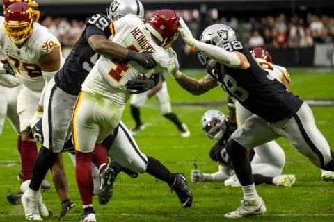 Raiders defensive end Clelin Ferrell (99) and defensive end Maxx Crosby (98) team up to take do ...