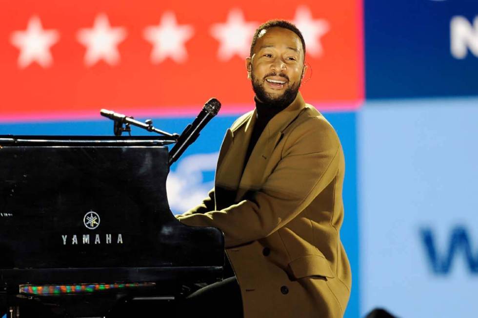 Performer John Legend plays the piano during a drive-in get out the vote rally featuring Democr ...