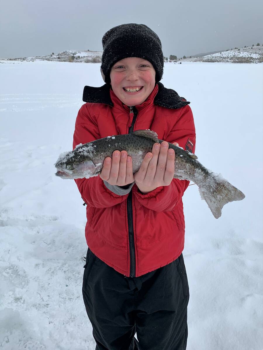 Austin Jenkins, 12, holds up a plump rainbow trout he pulled through the ice in February. With ...