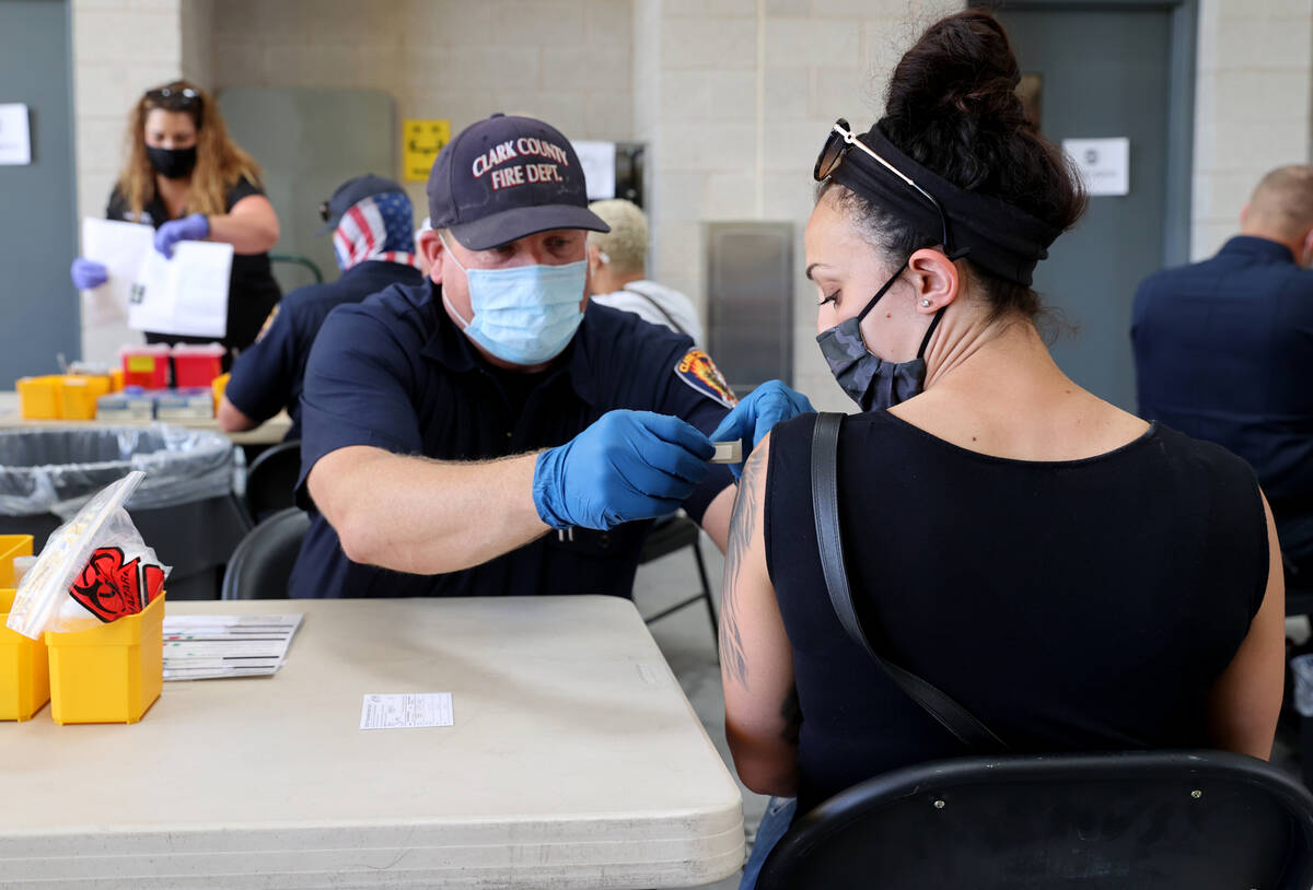 Clark County Fire Department Engineer Randy Cogburn gives a COVID-19 vaccine to Katye Burd, 30, ...