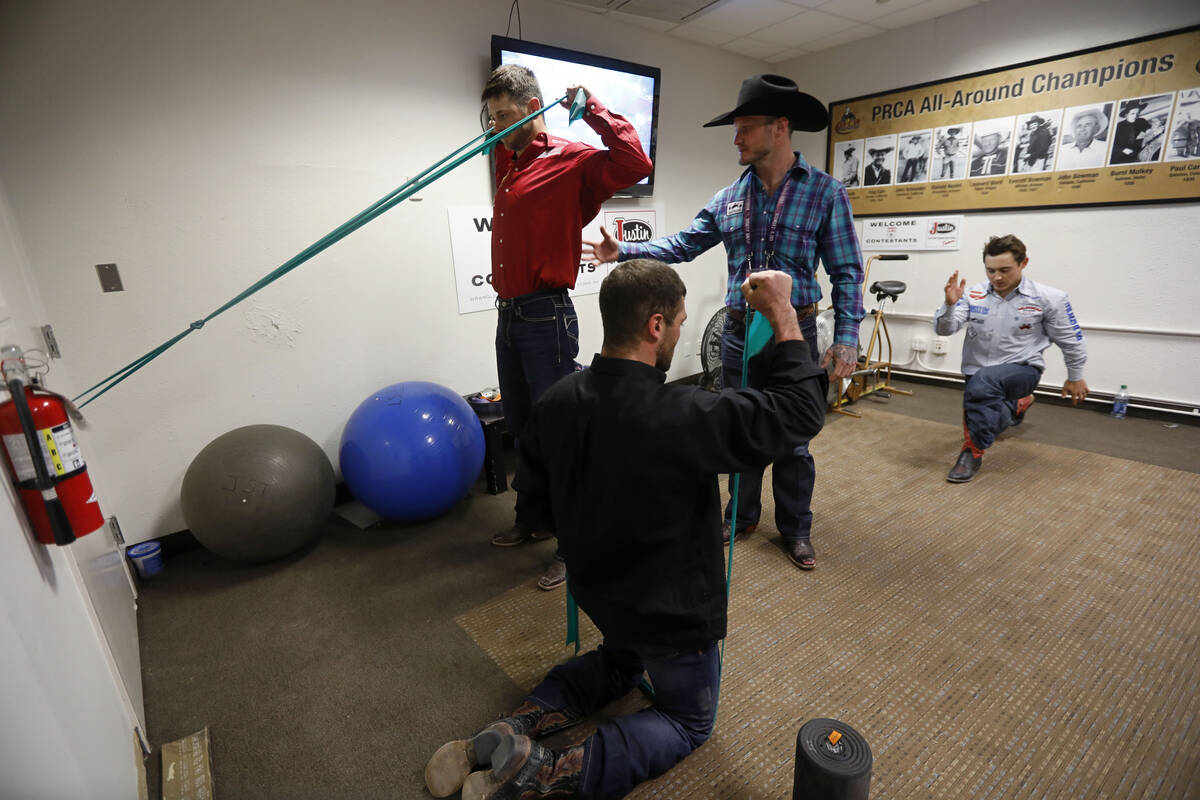 Former rodeo competitor Doug Champion, with cowboy hat, does physical therapy for competitors R ...