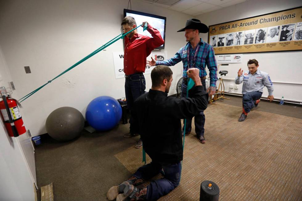 Former rodeo competitor Doug Champion, with cowboy hat, does physical therapy for competitors R ...