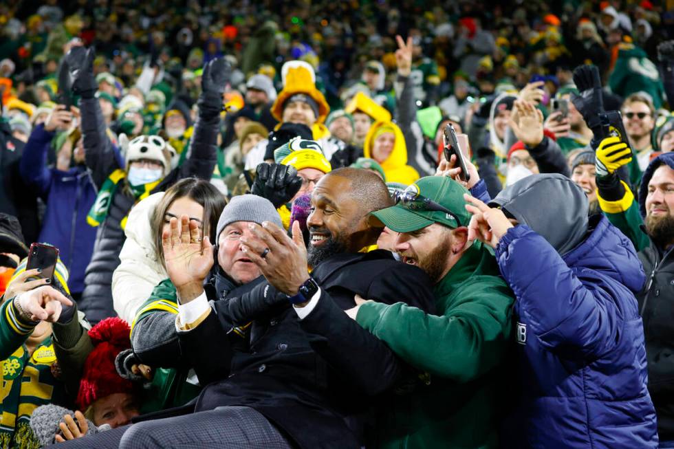 Former Green Bay Packer and HOF member Charles Woodson does a Lambeau leap with fans during hal ...