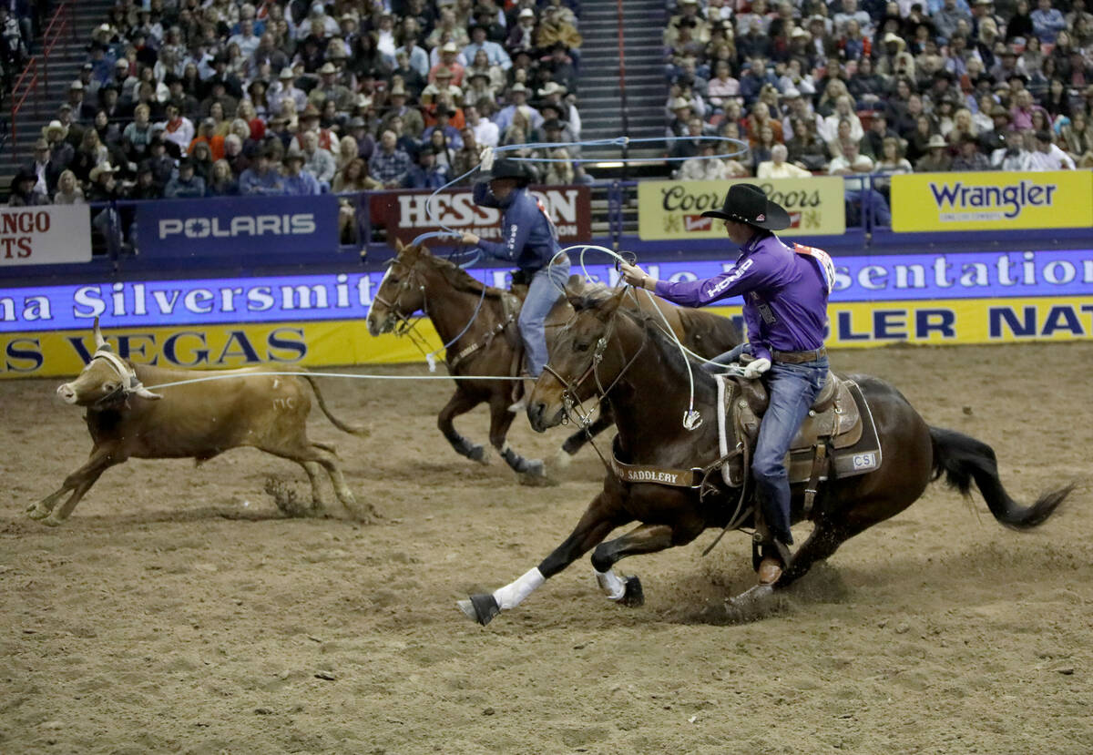Chase Tryan of Helena, Mont., left, and Brenten Hall of Jay, Okla. compete in the team roping e ...