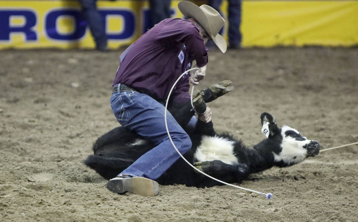 Hunter Herrin of Apache, Okla. competes in the tie-down roping event during the eighth go-round ...