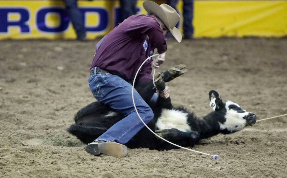 Hunter Herrin of Apache, Okla. competes in the tie-down roping event during the eighth go-round ...