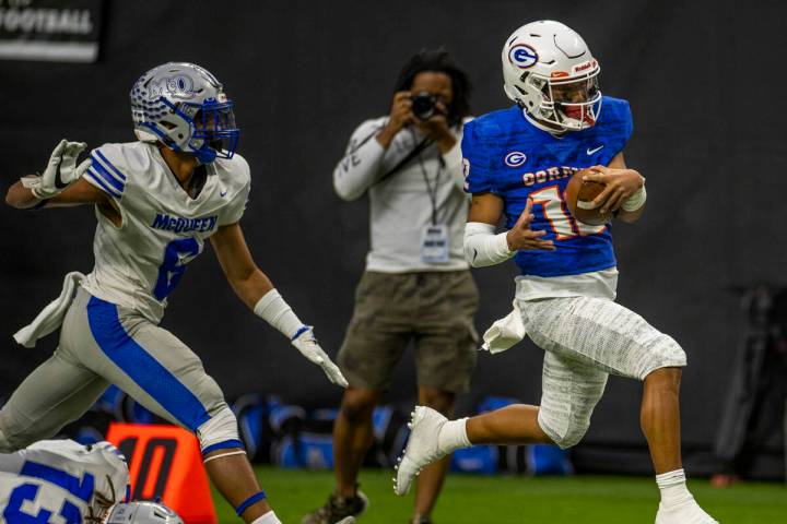 Bishop Gorman quarterback Micah Alejado (12) sprints down the sidelines past McQueen defensive ...