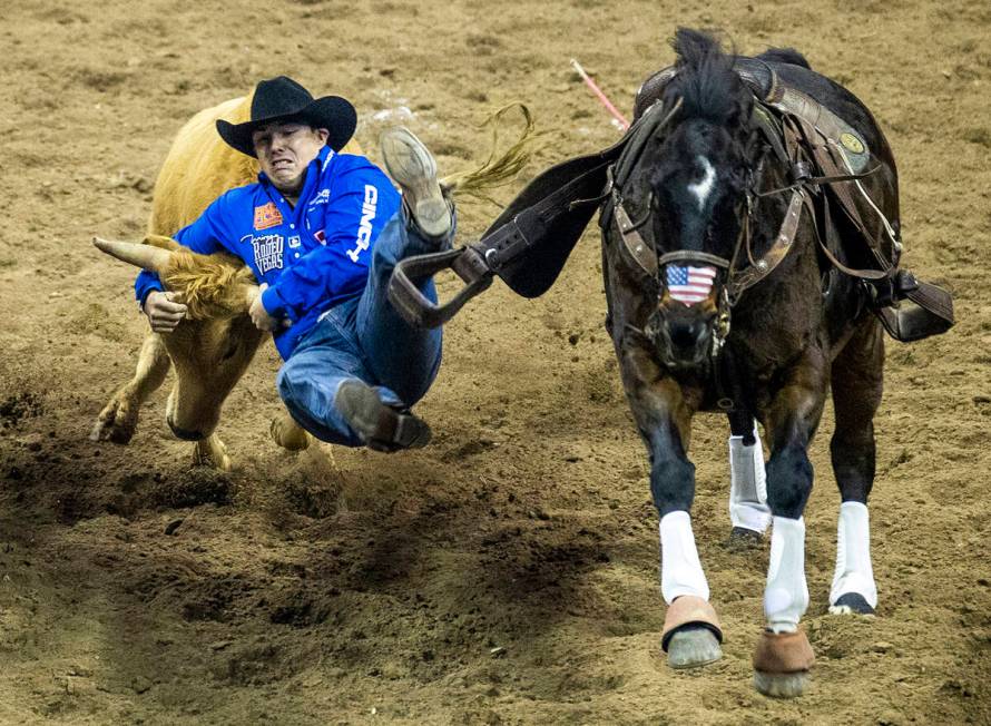 Dirk Tavenner of Rigby, ID., leaves his horse in Steer Wrestling to tie for first place during ...