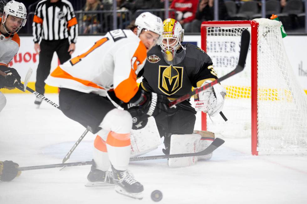 Golden Knights goaltender Laurent Brossoit (39) eyes the puck as Flyers right wing Travis Konec ...