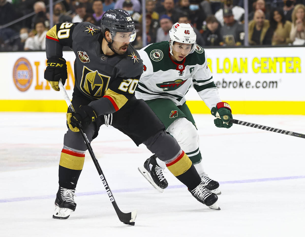 Golden Knights center Chandler Stephenson (20) skates with the puck under pressure from Minneso ...