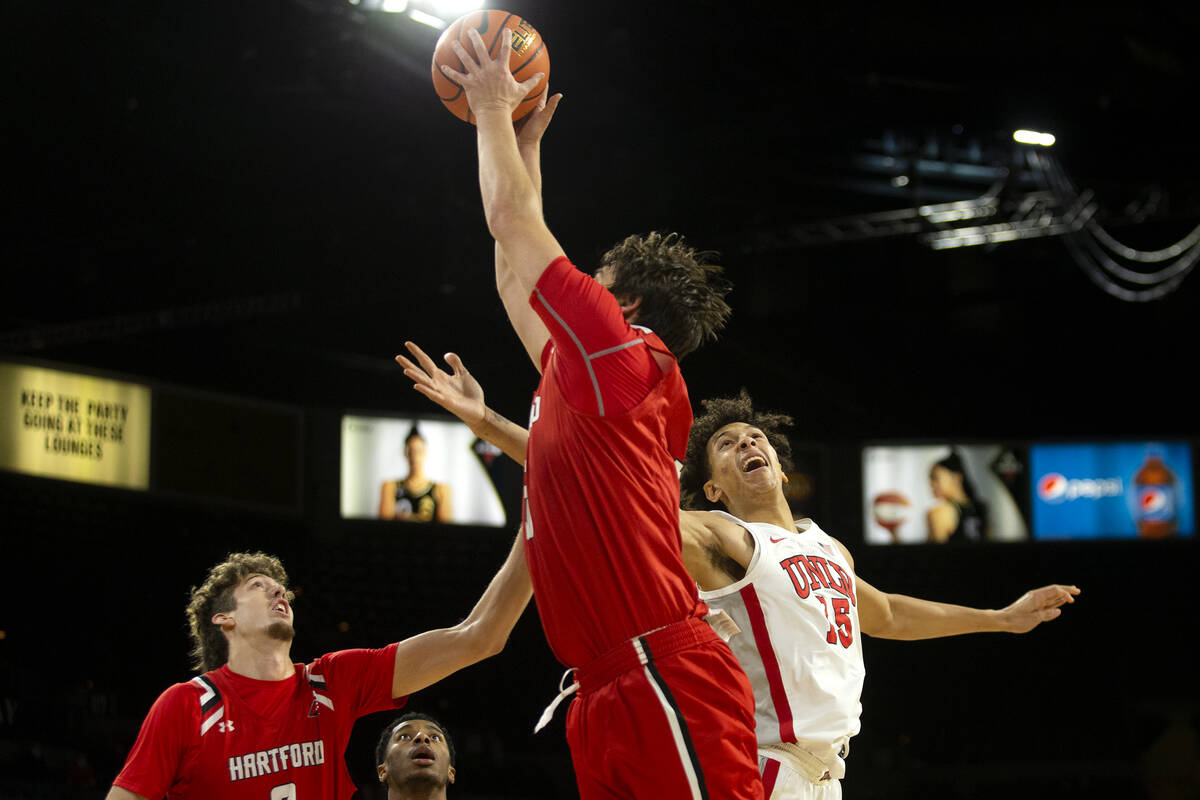 UNLV Rebels forward Reece Brown (15) jumps for the ball against Hartford Hawks guard Romain Box ...