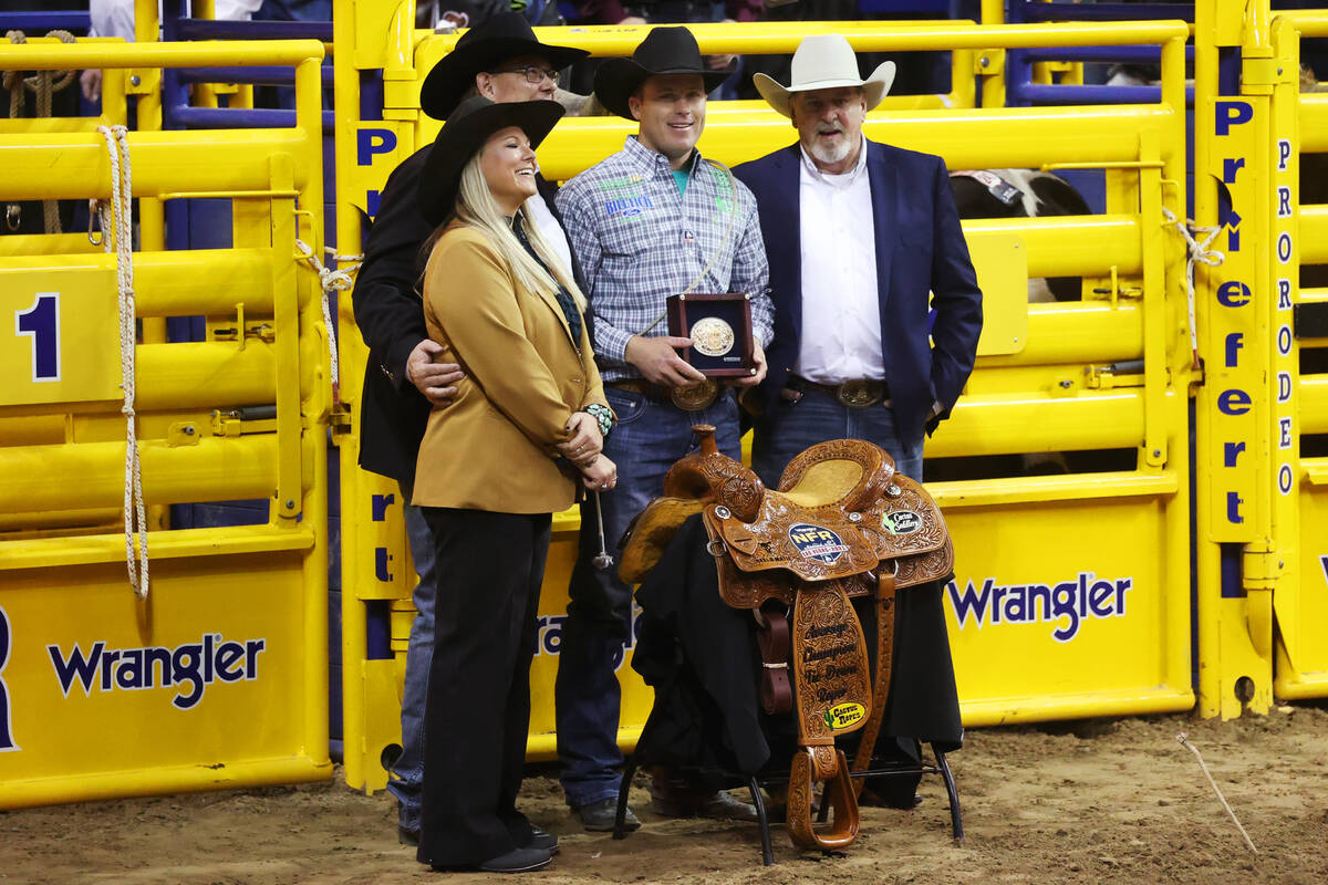 Caleb Smidt of Belville, Texas, third from left, is announced the winner of the tie-down event ...