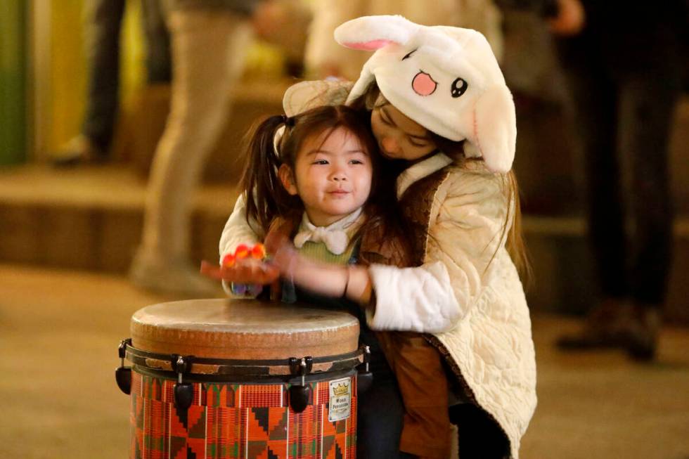 Adeline Montes, 10, of Las Vegas and her sister Olive Effendy, 3, play drum together, Saturday, ...