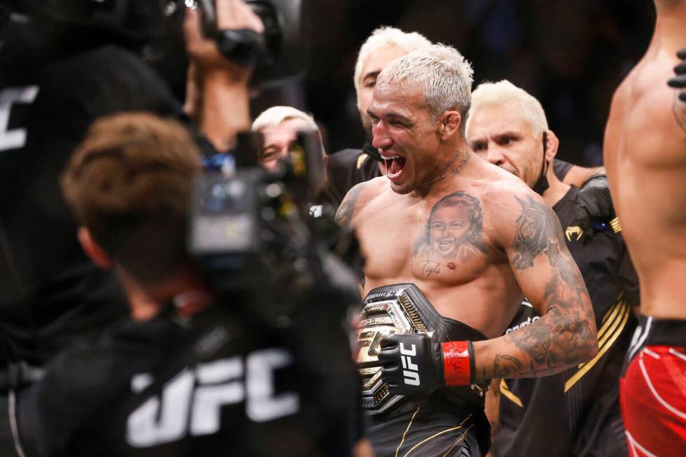 Charles Oliveira reacts after defeating Dustin Poirier by submission in a lightweight mixed mar ...