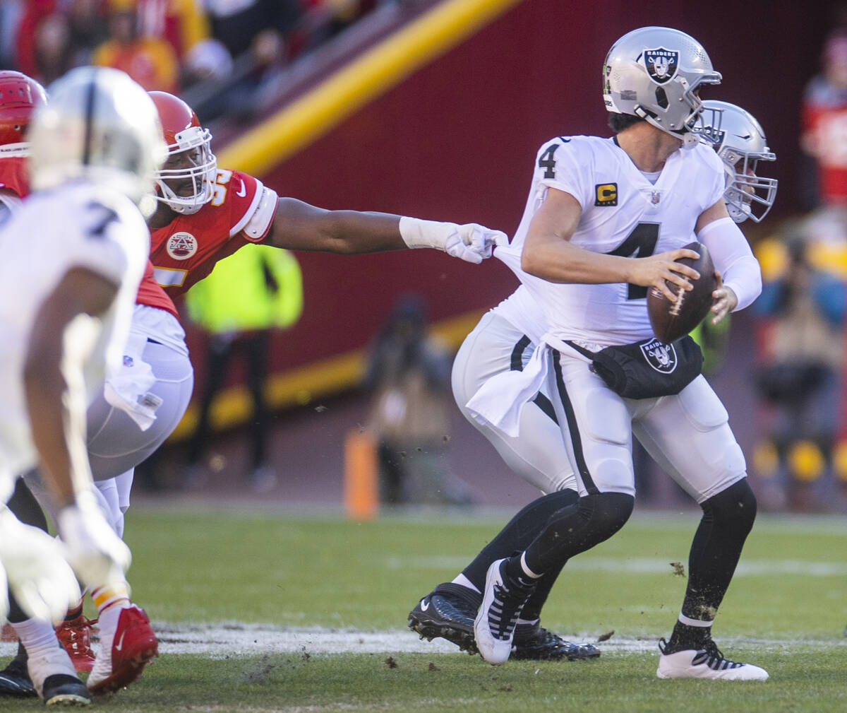 Raiders quarterback Derek Carr (4) is caught by a finger by Kansas City Chiefs defensive tackle ...