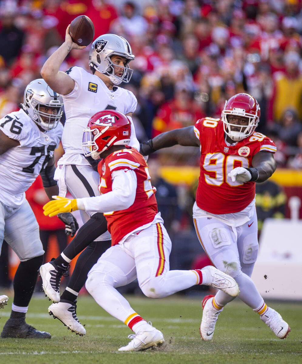 Raiders quarterback Derek Carr (4) looks for a receiver as Kansas City Chiefs defensive end Fra ...