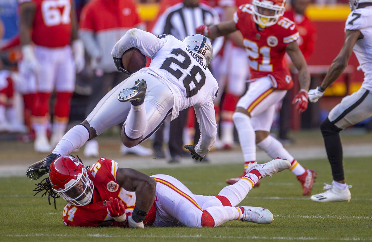 Kansas City Chiefs outside linebacker Nick Bolton (54) takes out the feet of Raiders running ba ...
