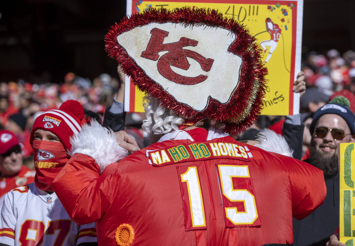 A Kansas City Chiefs fan in blowup Santa suit has a comical name on the back in the stands vers ...