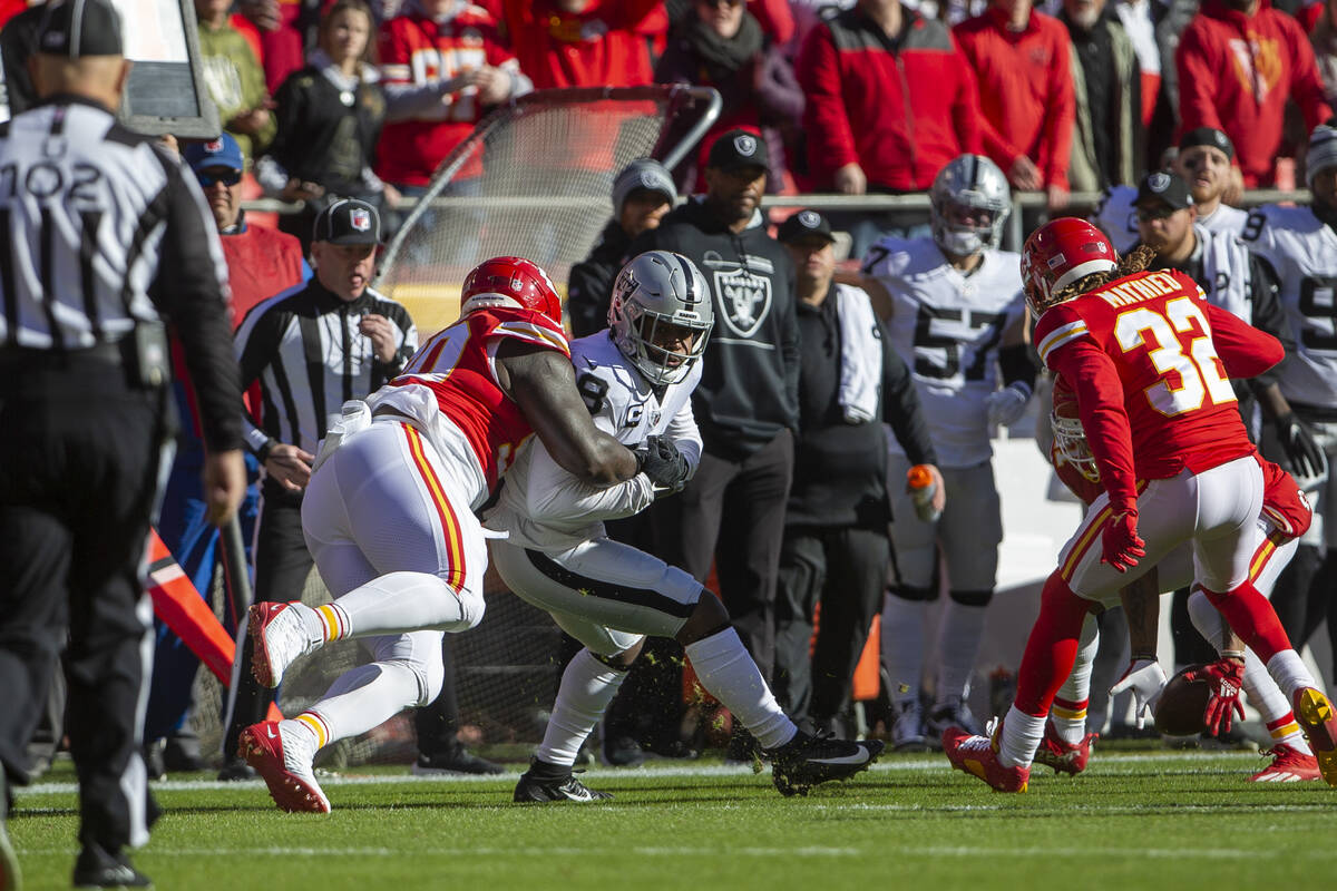 Kansas City Chiefs defensive tackle Jarran Reed (90) strips Raiders running back Josh Jacobs ( ...