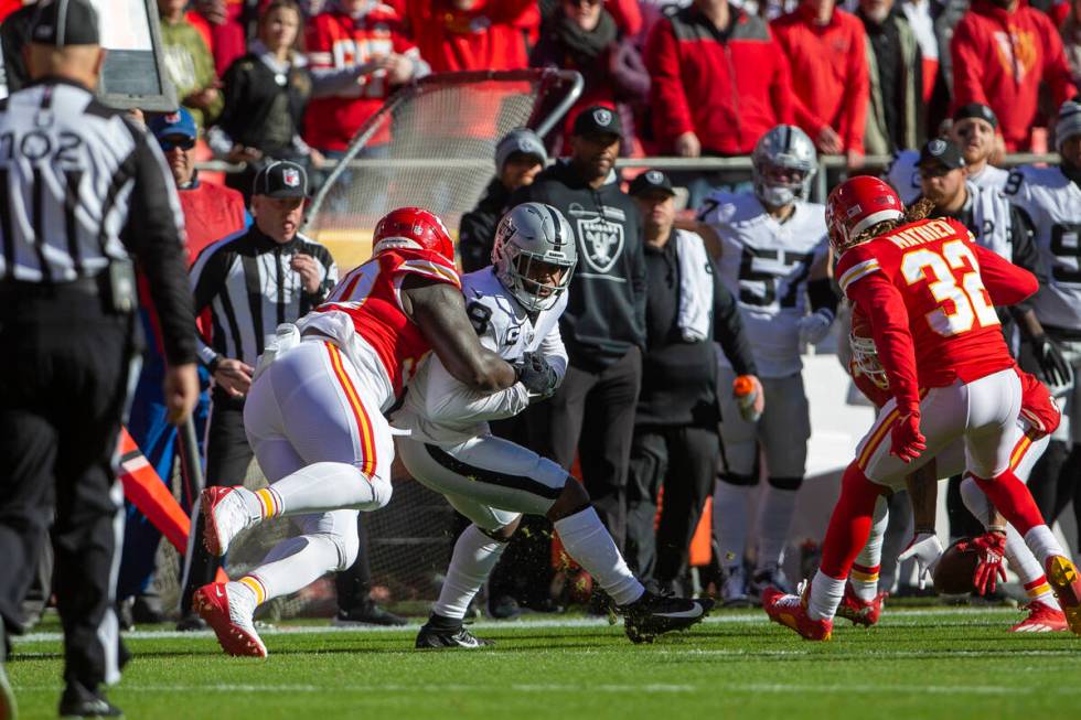 Kansas City Chiefs defensive tackle Jarran Reed (90) strips Raiders running back Josh Jacobs ( ...