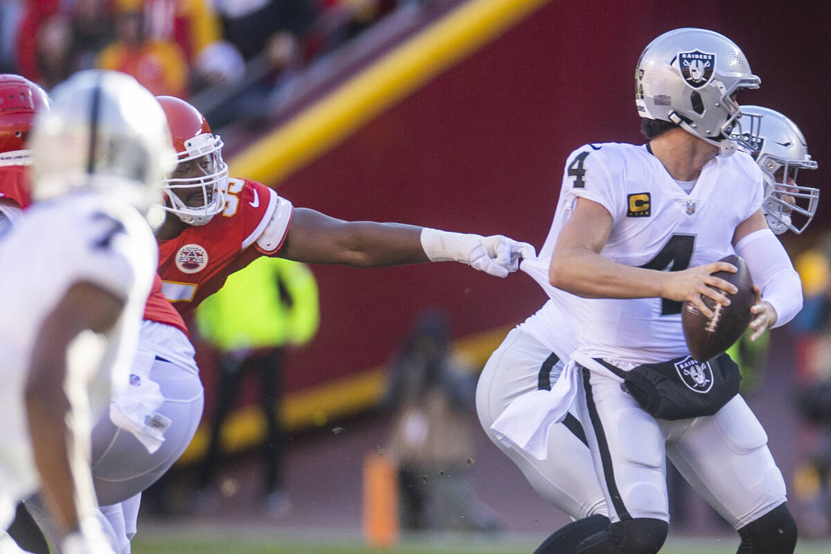 Raiders quarterback Derek Carr (4) is caught by a finger by Kansas City Chiefs defensive tackle ...