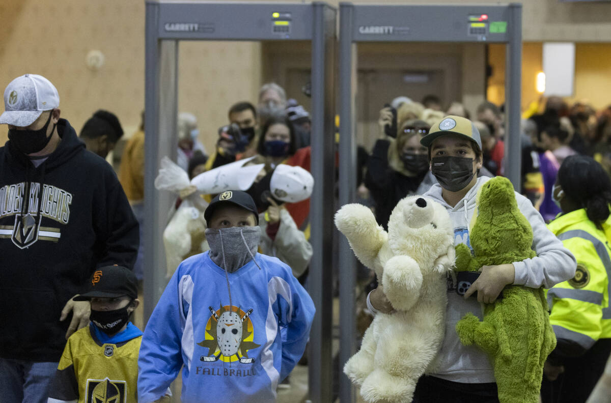 Fans bring stuffed animals through security to throw on the ice after the first Silver Knights ...