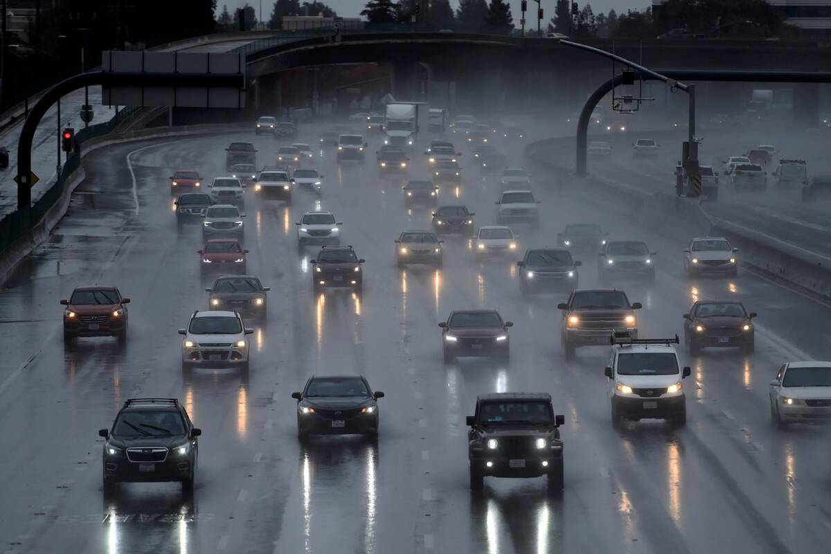 Motorist use their headlights as they drive in the rain on southbound I-680 in Pleasant Hill, C ...