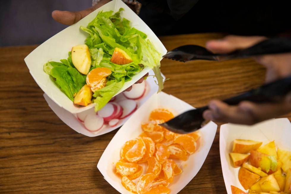 Kha'Laela Robinson, 10, makes a salad during a Gardening Club meeting at Dearing Elementary Sch ...