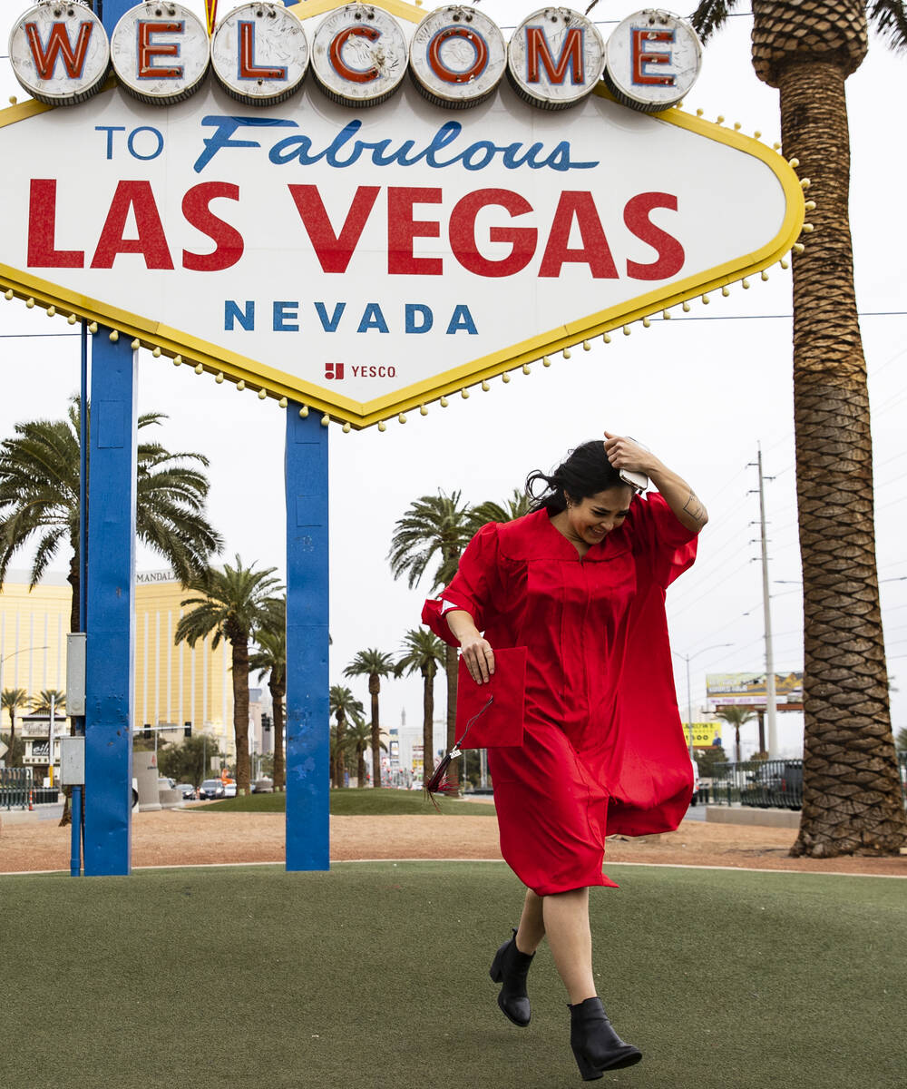 Anikka Hernandez of Las Vegas, UNLV graduate, has her photo session interrupted by heavy wind a ...
