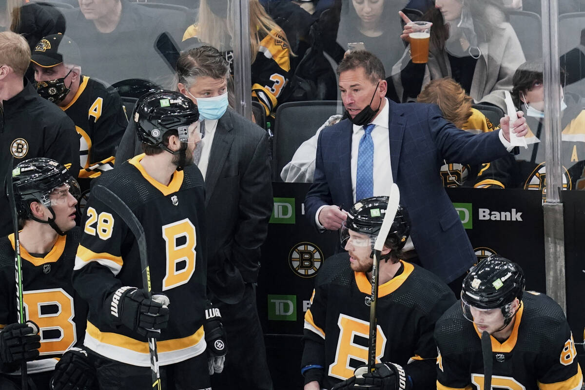 Boston Bruins head coach Bruce Cassidy, right, talks with his players during the first period o ...