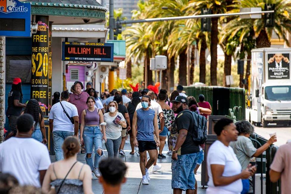 People walk along the Strip near The Venetian, most not wearing masks anymore on Friday, July 1 ...