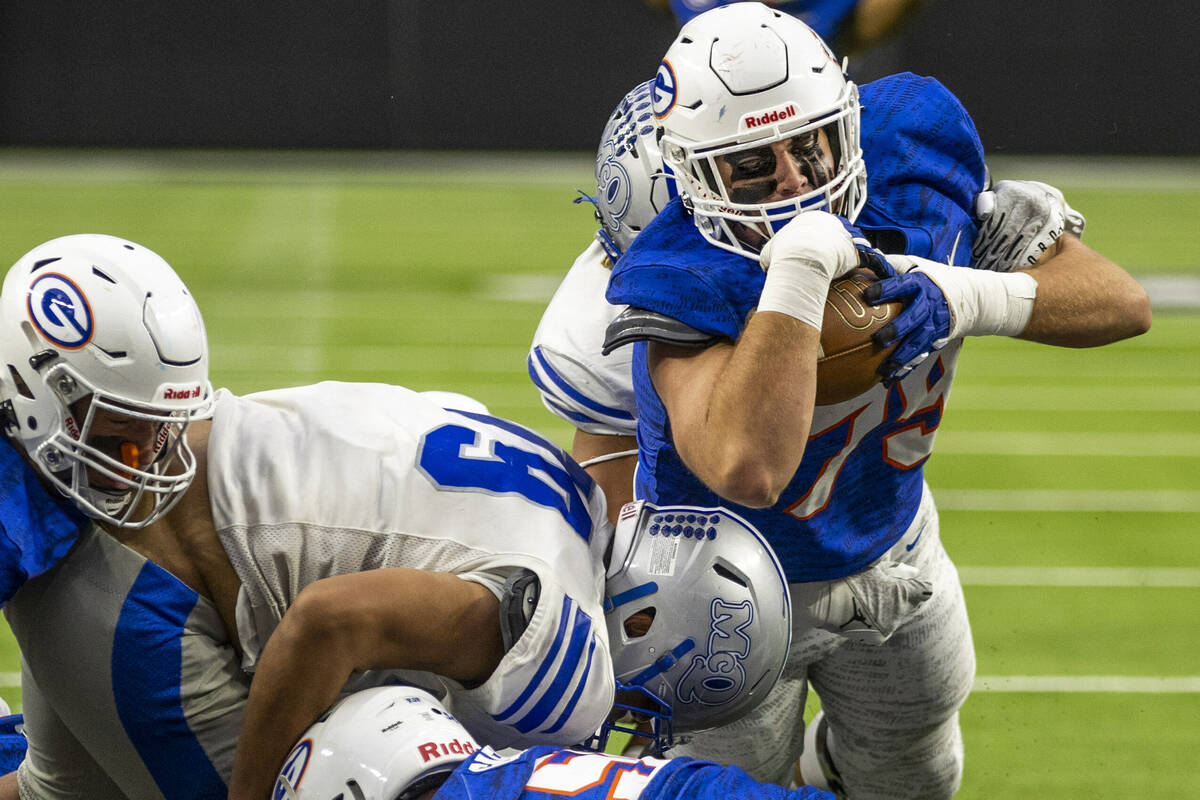 Bishop Gorman fullback Jake Taylor (79) dives into the end zone over McQueen defensive lineman ...