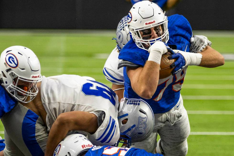 Bishop Gorman fullback Jake Taylor (79) dives into the end zone over McQueen defensive lineman ...