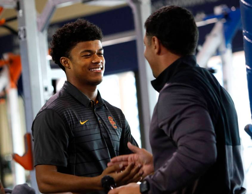 Bishop Gorman High School football player Fabian Ross, left, shakes hands with head coach Brent ...