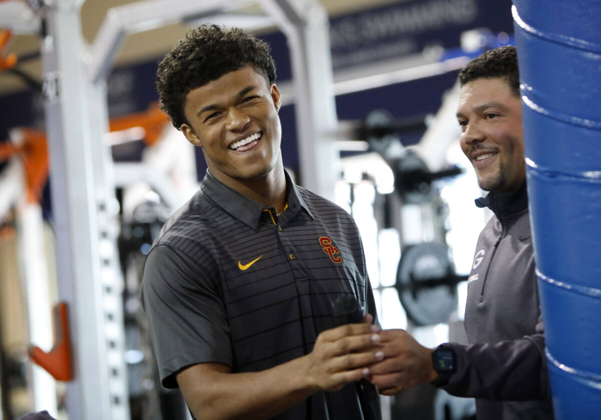 Bishop Gorman High School football player Fabian Ross left, receives a microphone from head coa ...