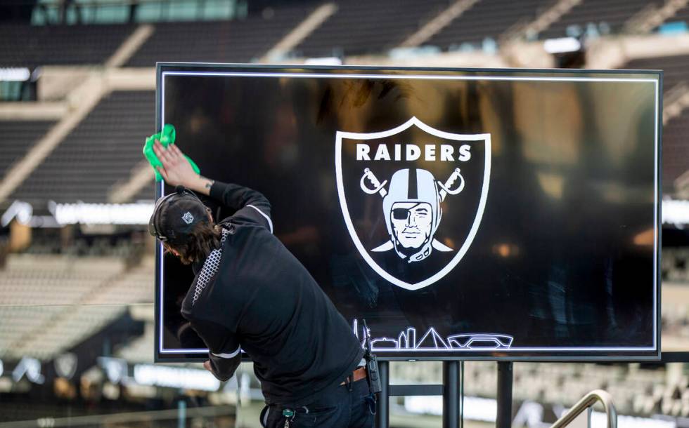 Video screens are cleaned before a press conference event announcing the NFL Super Bowl LVIII w ...