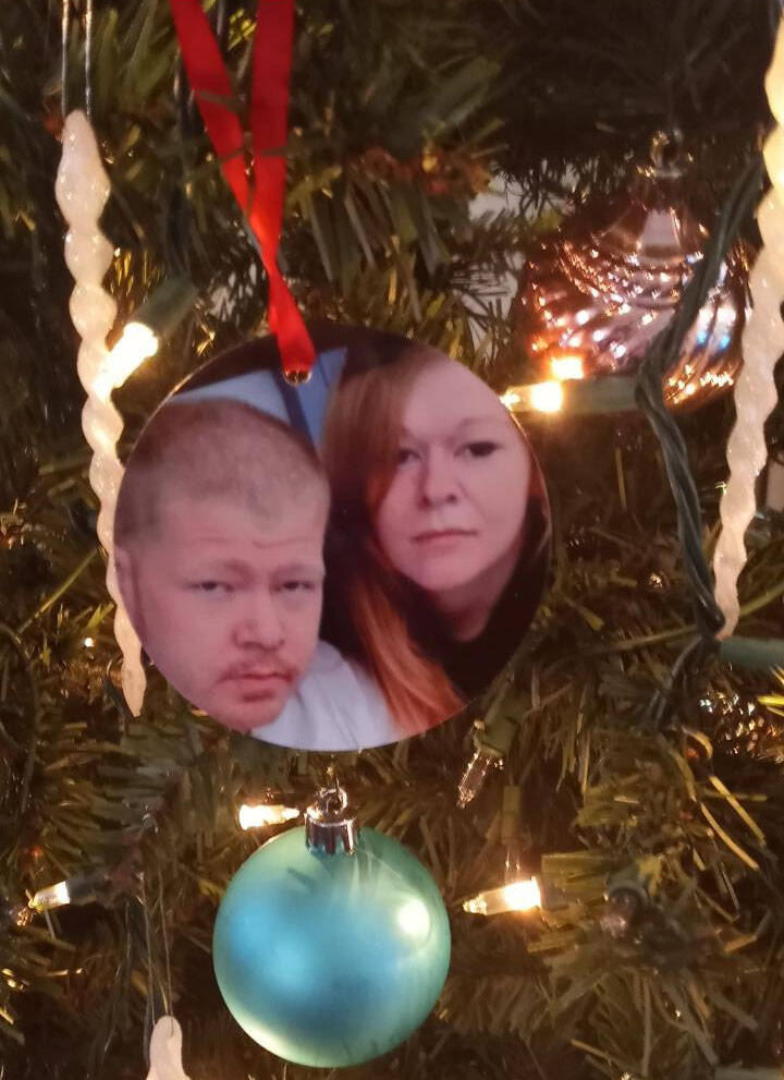 A Christmas tree ornament that has a photo of Jacob Stanley with his sister Roxanne Harrell han ...