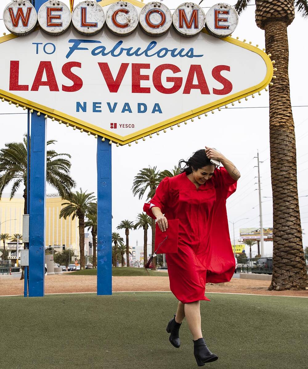 Anikka Hernandez of Las Vegas, a UNLV graduate, has her photo session interrupted by heavy wind ...