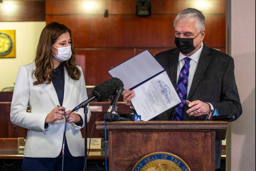 Gov. Steve Sisolak shows the official document he just signed to appoint Lisa Cano Burkhead as ...