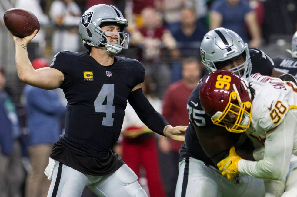 Raiders quarterback Derek Carr (4) makes a throw past Washington Football Team defensive end Ja ...