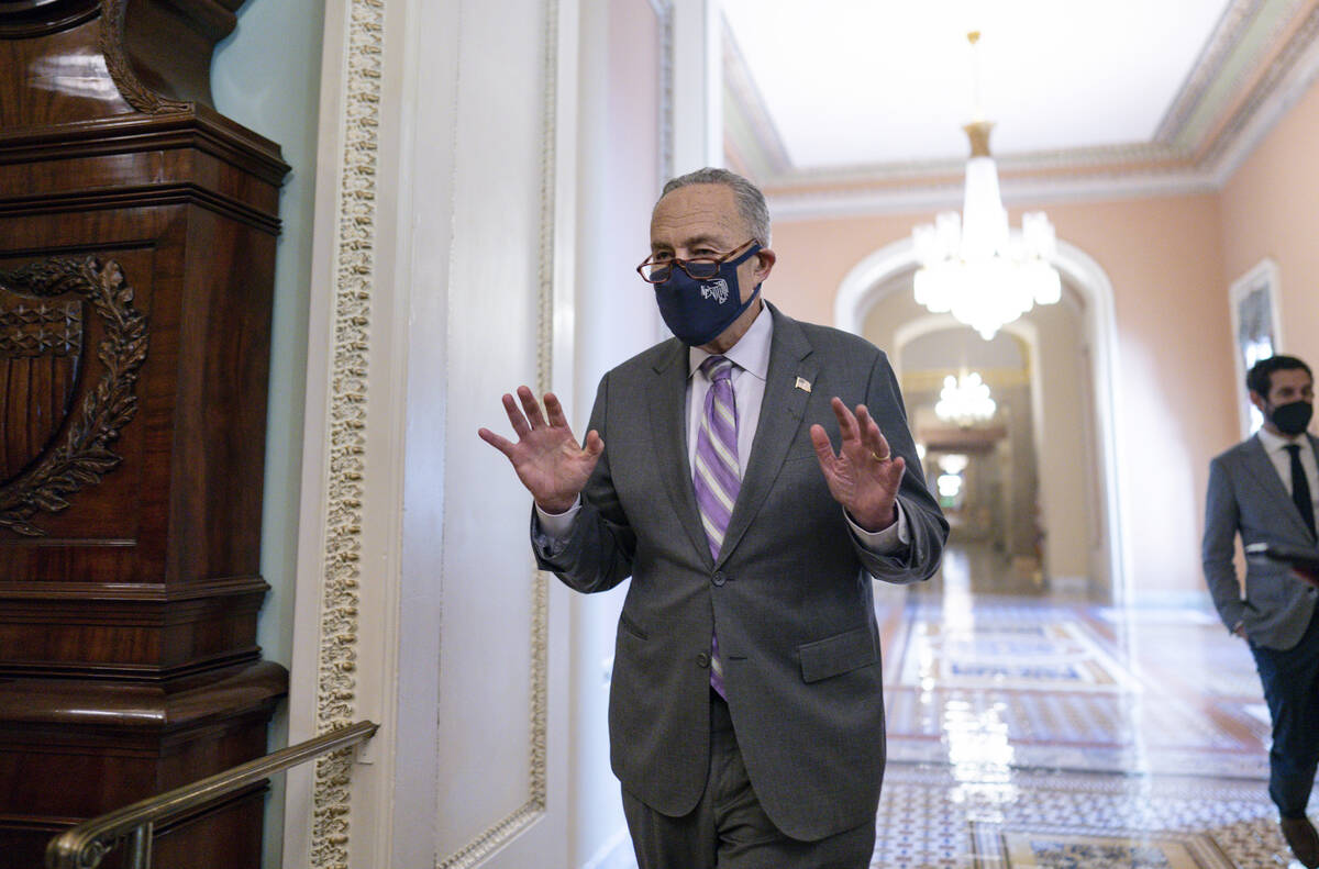Senate Majority Leader Chuck Schumer, D-N.Y., emerges from a Democratic Caucus meeting as the S ...