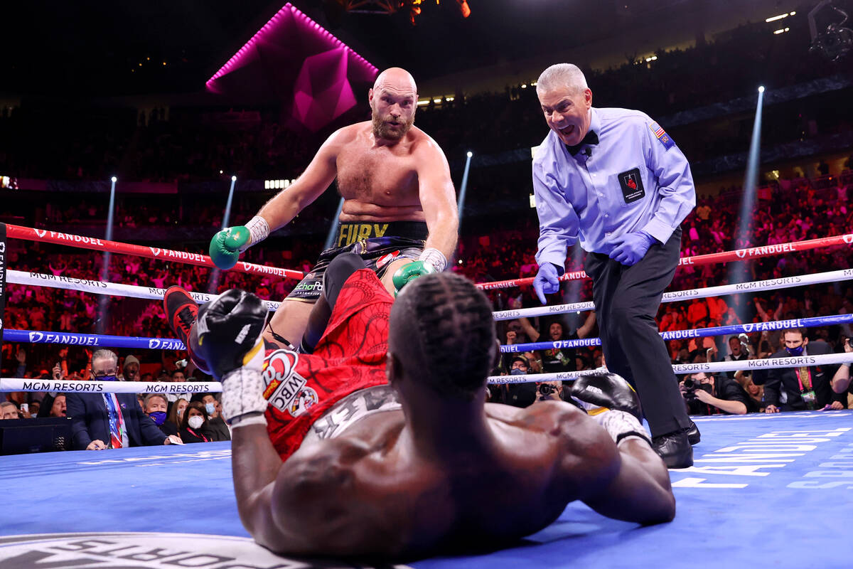Tyson Fury, left, knocks down Deontay Wilder in the third round of a WBC Heavyweight World Cham ...